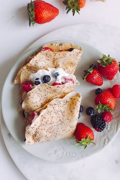 a white plate topped with fruit next to tortilla shells and strawberries on top of it