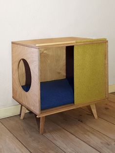 a small wooden cabinet with a blue cushion in the front and yellow cushions in the back