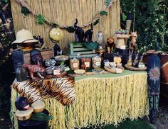 a table topped with lots of different types of food and decor on top of a grass covered field