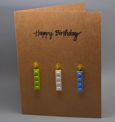 three legos are placed in front of a card with the words happy birthday written on it