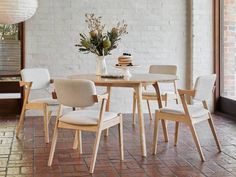 a dining table with four chairs and a vase filled with flowers on top of it