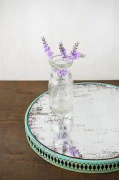 a glass jar with some purple flowers in it