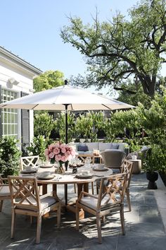 an outdoor dining table with chairs and umbrella