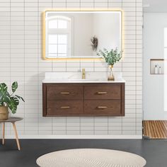 a bathroom with a sink, mirror and potted plant on the floor in front of it