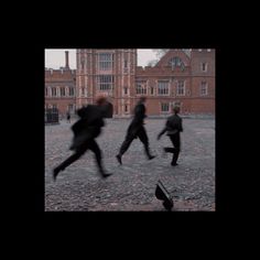 blurry photograph of people running in front of an old building on a rainy day