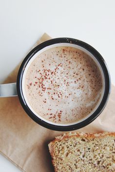 a cup of coffee and some bread on a napkin