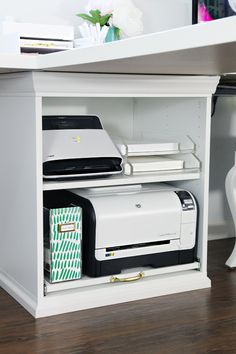 a white desk with a printer and other office supplies on the shelf next to it