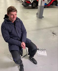 a man sitting on the ground in a parking garage