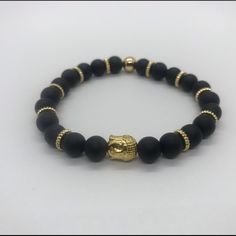 Gold Buddha And Black Beads Combination Creating A Great Piece Of Jewelry For Any Occasion Casual Beaded Bracelets With Black Beads As Gift, Black Beaded Bracelet Gift, Black Beaded Bracelets For Gifts, Casual Black Beads Wristband Gift, Adjustable Black Onyx Bead Stretch Bracelet, Adjustable Onyx Stretch Bracelet With Black Beads, Adjustable Onyx Beaded Bracelets, Black Stretch Bracelet With Spacer Beads As Gift, Black Bracelets With Spacer Beads As Gift