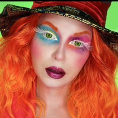 a woman with bright orange hair and green eyes wearing a red hat, makeup looks like a witch