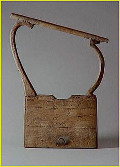 an old wooden object with a handle on it