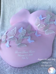 a pink heart shaped box with butterflies on the lid and name written in white lettering