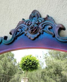 a mirror that is on the side of a wall with a flower decoration in it