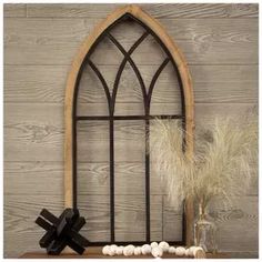 a wooden shelf with a vase and some feathers on top of it next to a window