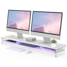 two computer monitors sitting next to each other on top of a white desk with keyboard and mouse