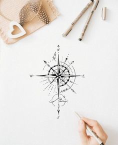 someone is drawing a compass on a piece of paper