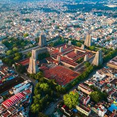 an aerial view of a city with many buildings and lots of trees in the foreground