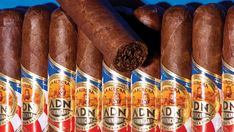 several cigars are lined up in rows on a blue background with the top one open