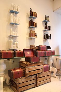 several wooden boxes stacked on top of each other in front of shelves filled with bottles