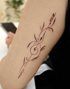 a woman's arm with an arrow tattoo on it