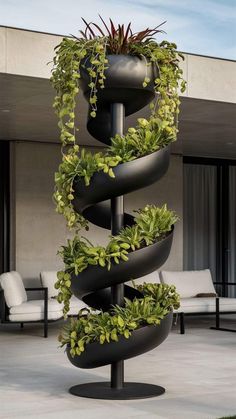 a tall spiral planter with plants growing in it's sides and on top