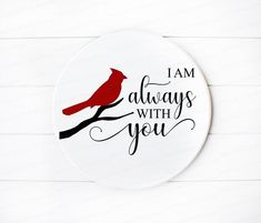 a red bird sitting on top of a white plate with the words i am always with you