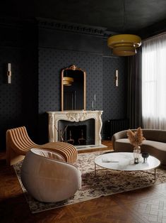 a living room filled with furniture and a fire place next to a large window on top of a hard wood floor