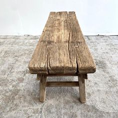 a wooden bench sitting on top of a carpeted floor next to a white wall