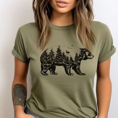 Bear Silhouette T-Shirt, Bear Graphic Tee, Nature Bear Shirt, Wildlife T-Shirt,Bear Inside Design, Animal Lover's Tee, Forest Bear Shirt, Unique Bear Shirt. Showcase your love for wildlife with our Bear Silhouette T-Shirt, featuring a detailed bear design inside a bear silhouette. Perfect for nature enthusiasts and animal lovers, this unique tee captures the spirit of the great outdoors. Made from high-quality fabric, it offers both comfort and durability for everyday wear. The unisex soft-style t-shirt puts a new spin on casual comfort. Made from very soft materials, this tee is 100% cotton for solid colors. Heather colors and sports grey include polyester. The shoulders have twill tape for improved durability. There are no side seams. The collar is made with ribbed knitting to prevent cu Trendy Crew Neck T-shirt With Bear Print, Casual Green T-shirt With Print, Casual Green Printed T-shirt, Casual Crew Neck Top With Bear Print, Green Crew Neck Top With Print, Graphic Tee With Bear Print And Crew Neck, Cute Bear Print Crew Neck T-shirt, Cute Short Sleeve Tops With Bear Print, Cute Bear Print Short Sleeve Tops