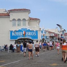 people walking on the boardwalk in front of shops