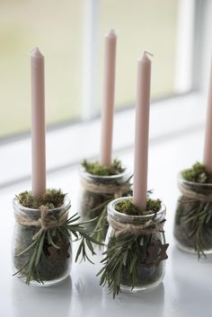 small jars filled with moss and lit candles