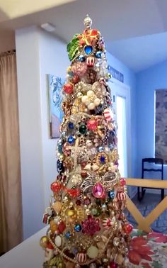 a christmas tree with ornaments on it in a living room