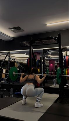 a woman squatting down in the gym