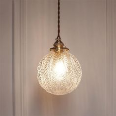 a glass light fixture hanging from a ceiling