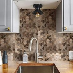 a kitchen sink sitting under a metal faucet next to a wooden counter top