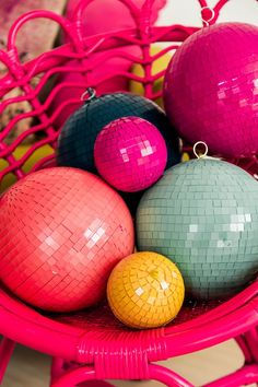 some colorful balls are sitting on a pink chair