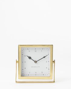 a small square clock sitting on top of a table