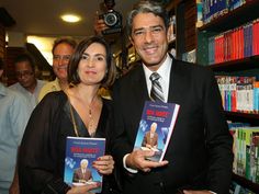 a man and woman standing next to each other holding books