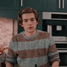 a young man standing in front of a kitchen counter