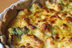 a casserole dish with broccoli and cheese in it on a table