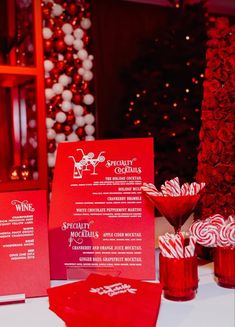 red menus and candy canes on a table in front of a christmas tree