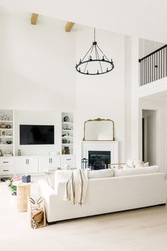 a living room filled with furniture and a flat screen tv mounted on a wall above a fire place