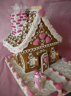 a gingerbread house with pink hearts on it