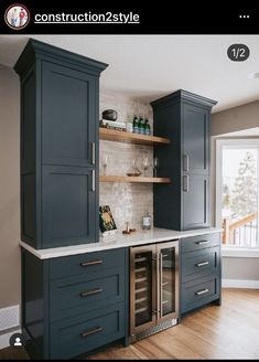 a kitchen with dark blue cabinets and white counter tops, built in wine coolers