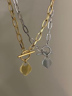 "The Heart Toggle Necklace in Gold or Silver ✨ Solid Stainless Steel (18k gold plated/silver steel) & Tarnish Proof! Featuring a flat heart lock pendant paired with a chunky paperclip link chain and front toggle for easy removal 🤍 Approx. 17\" in length  Handmade with love! Unisex ✨" Metal Heart Necklace With Chunky Chain For Gift, Tarnish-resistant Silver-tone Heart Necklace, Valentine's Day Metal Heart Necklace Tarnish Resistant, Gold Heart Toggle Necklace With Lobster Clasp, Gold Heart Pendant Toggle Necklace, Gold Toggle Necklace With Heart Pendant, Tarnish Resistant Metal Heart Chain Necklace, Valentine's Day Metal Chain Necklace With Heart Charm, Gold Heart Toggle Necklace With Adjustable Chain