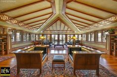 a large living room filled with lots of furniture and wooden beams on top of the ceiling