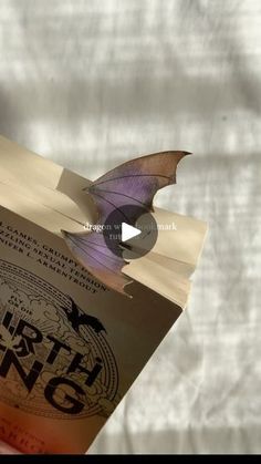 a purple bat flying over an open book