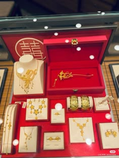 a display case filled with lots of gold jewelry and bracelets on top of a table