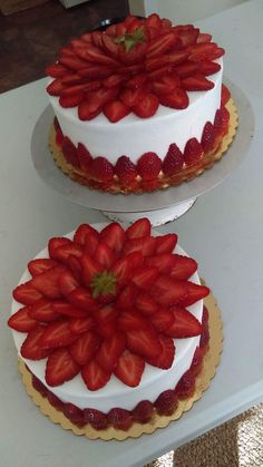 two cakes decorated with strawberries on top of each other