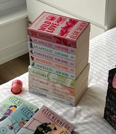 a stack of books sitting on top of a bed